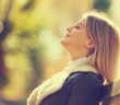Young happy woman enjoying fresh air in autumn, intentionally toned.