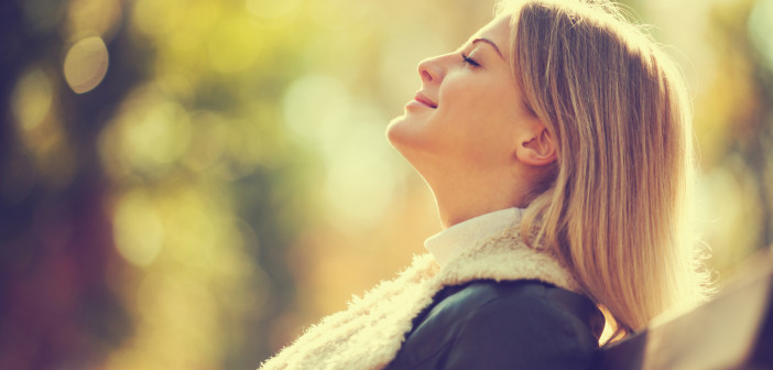 Young happy woman enjoying fresh air in autumn, intentionally toned.
